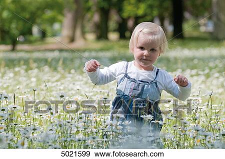Stock Photo - Blond girl on a flower meadow . Fotosearch