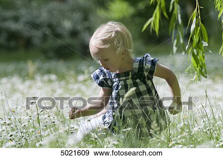 Blond girl on a flower meadow View Large Photo Image Stock Photo - Blond girl on a flower meadow . Fotosearch