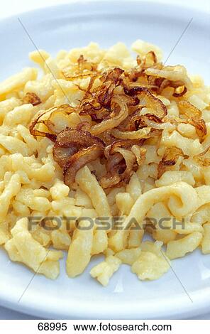 Stock Photography - Boiled noodles and fried onion rings on plate . Fotosearch
