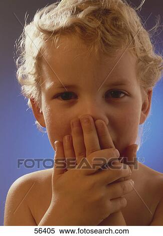 Stock Photography - Boy holding hand before mouth . Fotosearch