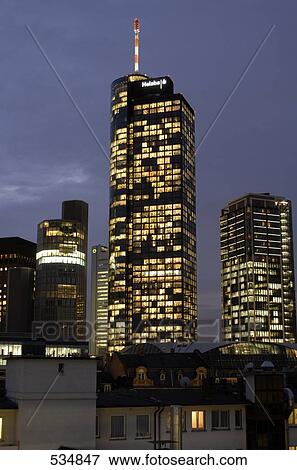 Buildings in city lit up against evening sky, Frankfurt, Germany View Large Photo Image Stock Photo - Buildings in city lit up against evening sky, Frankfurt, Germany . Fotosearch