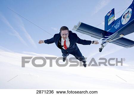 Businessman jumping out of propeller plane, Switzerland View Large Photo Image Stock Photograph - Businessman jumping out of propeller plane, Switzerland . Fotosearch
