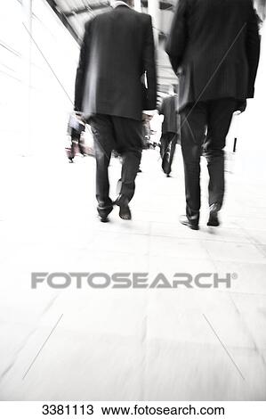 Businessmen walking on a pavement, low angle view View Large Photo Image Stock Image - Businessmen walking on a pavement, low angle view . Fotosearch