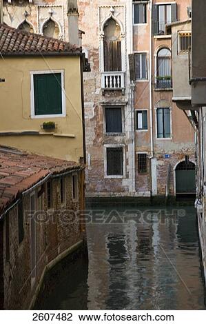 Stock Image - Canal flowing through city, Grand Canal, Veneto, Venice, Italy . Fotosearch