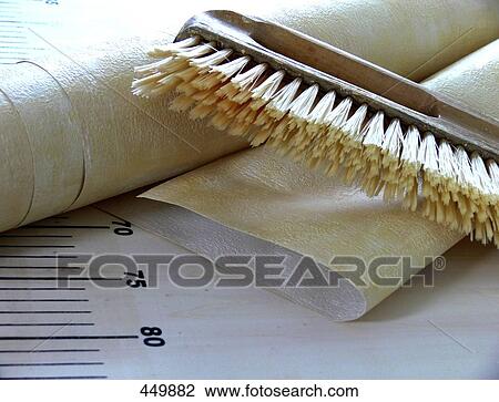 Stock Image - Close-up of brush and roll of wallpaper . Fotosearch