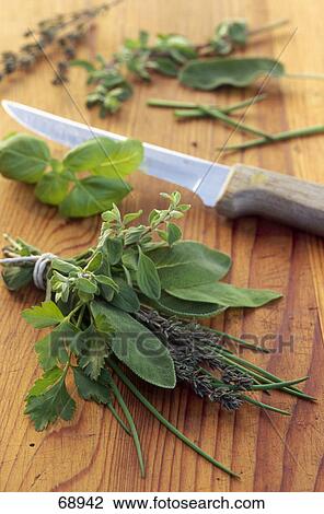 Stock Image - Close-up of bunch of herbs and kitchen knife . Fotosearch