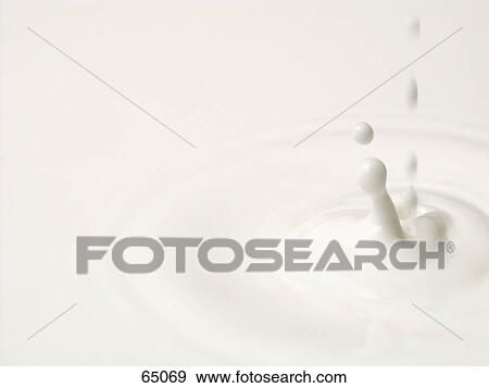 Stock Photo - Close-up of drops falling in milk . Fotosearch