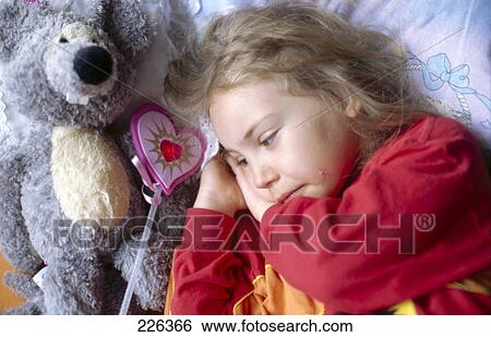Close-up of girl lying besides teddy bear View Large Photo Image Stock Photograph - Close-up of girl lying besides teddy bear . Fotosearch