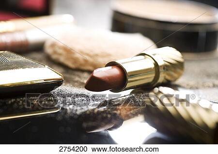 Stock Image - Close-up of lipstick and face powder . Fotosearch