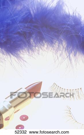 Stock Image - Close-up of lipstick, false eyelashes and fur boa . Fotosearch