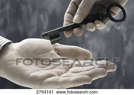 Stock Image - Close-up of person's hand handling key . Fotosearch