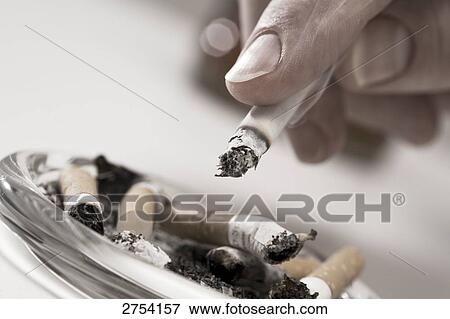 Stock Photo - Close-up of person's hand holding cigarette . Fotosearch