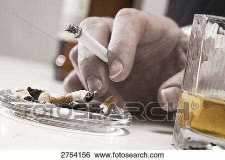 Close-up of person's hand holding cigarette View Large Photo Image Stock Photograph - Close-up of person's hand holding cigarette . Fotosearch