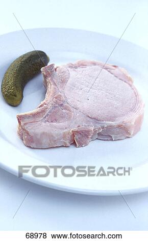 Stock Photo - Close-up of pork ribs and cucumber on plate . Fotosearch