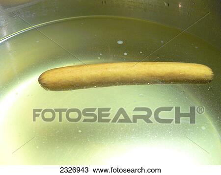 Stock Image - Close-up of sausage and oil in pan . Fotosearch