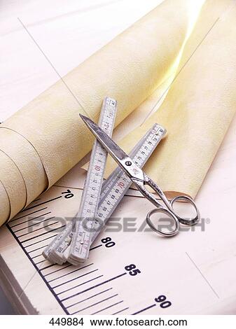 Close-up of scissors with a tape measure and a roll of wallpaper View Large Photo Image Picture - Close-up of scissors with a tape measure and a roll of wallpaper . Fotosearch