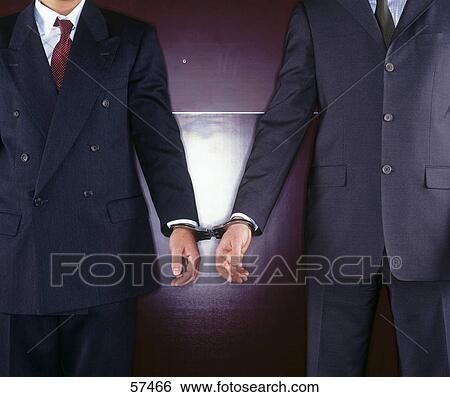 Stock Photograph - Close-up of two businessmen handcuffed together . Fotosearch