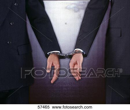 Close-up of two businessmen handcuffed together View Large Photo Image Stock Photography - Close-up of two businessmen handcuffed together . Fotosearch