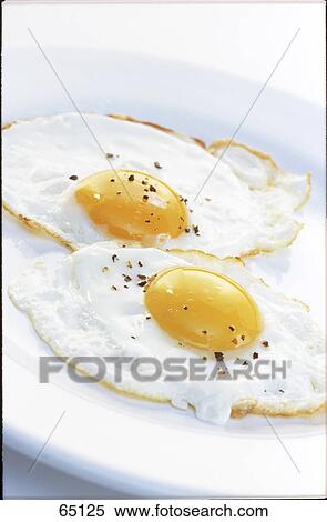 Close-up of two fried eggs on plate View Large Photo Image Stock Photography - Close-up of two fried eggs on plate . Fotosearch