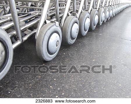 Stock Image - Close-up of wheels of luggage carts . Fotosearch