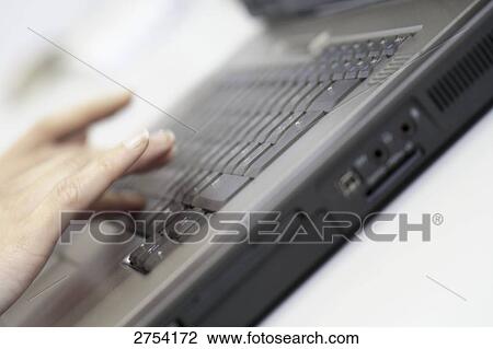 Stock Image - Close-up of woman's hand using laptop . Fotosearch