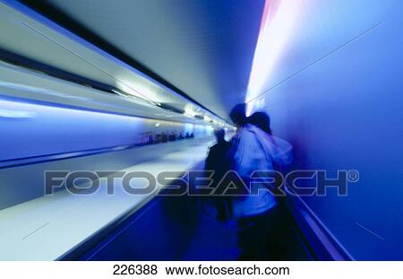 Stock Photo - Defocused view of people on conveyor belt . Fotosearch