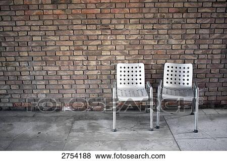 Empty chairs in front of brick wall View Large Photo Image Stock Photo - Empty chairs in front of brick wall . Fotosearch