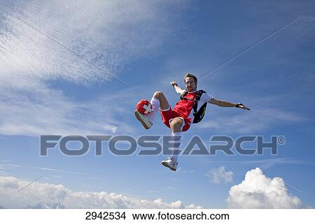 football player doing parachute jumping, full shot View Large Photo Image Picture - football player doing parachute jumping, full shot . Fotosearch