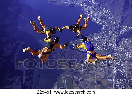 Stock Image - Four people parachuting in formation . Fotosearch