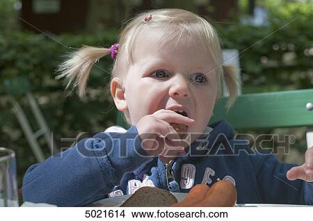 Picture - Girl eating sausage . Fotosearch