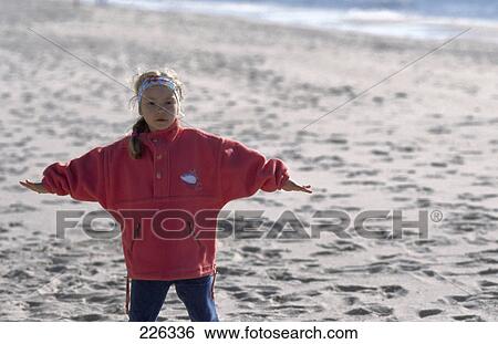 Stock Photograph - Girl stretching her arms on beach . Fotosearch