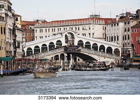 Picture - Gondola and motorboat on canal close to bridge, Venice, Italy . Fotosearch