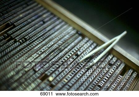 Stock Image - High angle view of tweezers on printing blocks . Fotosearch