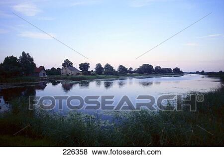 Stock Photo - Houses along river at dusk . Fotosearch