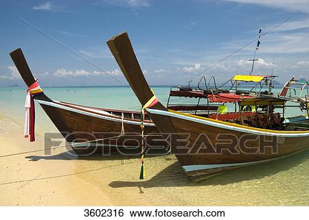 Longtail boats on the beach, Ko Ngai Island, Thailand View Large Photo Image Stock Photograph - Longtail boats on the beach, Ko Ngai Island, Thailand . Fotosearch