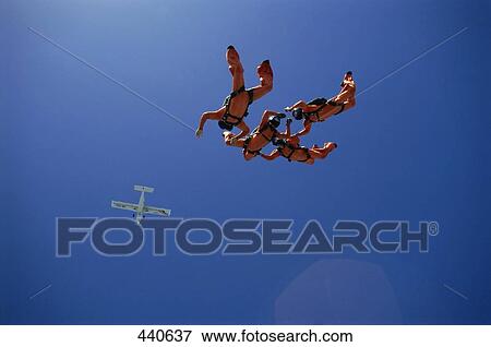 Stock Photo - Low angle view of four people skydiving . Fotosearch