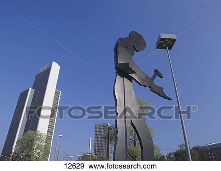 Low angle view of hammering man sculpture, Frankfurt, Hesse, Germany View Large Photo Image Stock Photo - Low angle view of hammering man sculpture, Frankfurt, Hesse, Germany . Fotosearch