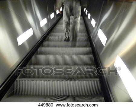Stock Image - Low angle view of man on escalator . Fotosearch