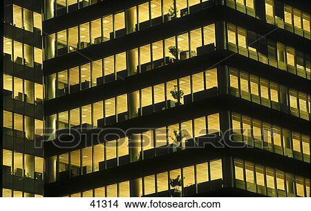 Picture - Low angle view of office building lit up at night . Fotosearch