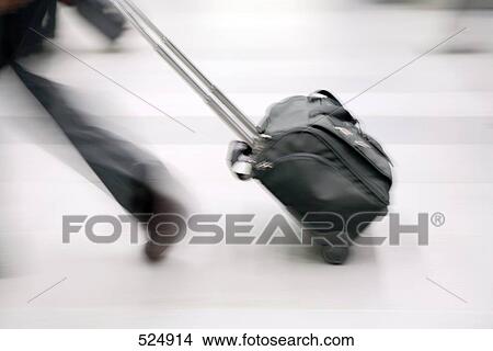 Low section view of person pulling luggage View Large Photo Image Picture - Low section view of person pulling luggage . Fotosearch