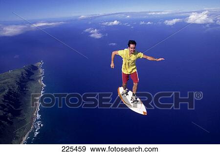 Stock Photo - Man skydiving on skateboard, Hawaii, USA . Fotosearch