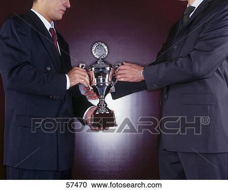 Mid section view of two businessmen holding trophy View Large Photo Image Stock Image - Mid section view of two businessmen holding trophy . Fotosearch