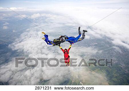 Stock Image - parachute jumping in formation, full shot . Fotosearch