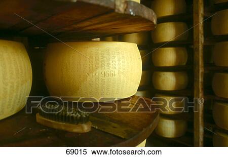 Stock Photography - Parmesan Cheese on shelves in storage room, Emilia-Romagna, Italy . Fotosearch