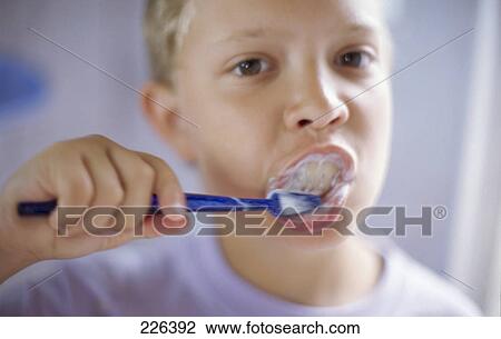 Stock Image - Portrait of boy brushing teeth . Fotosearch