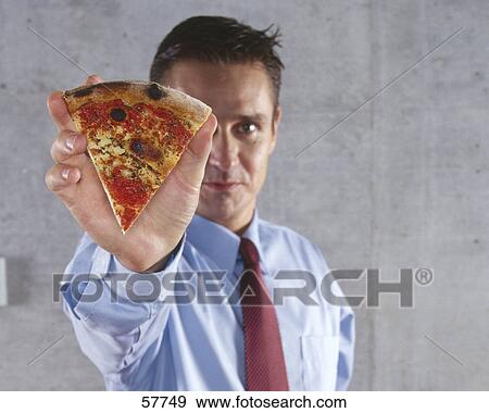 Stock Photo - Portrait of businessman holding pizza piece . Fotosearch