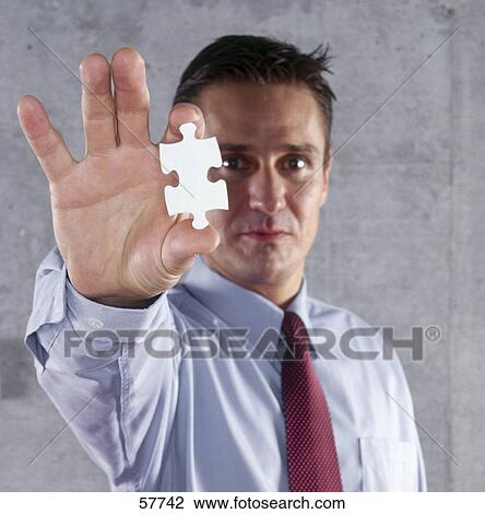 Portrait of businessman holding puzzle piece View Large Photo Image Stock Image - Portrait of businessman holding puzzle piece . Fotosearch