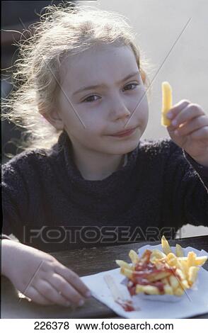 Portrait of girl eating french fries View Large Photo Image Stock Photo - Portrait of girl eating french fries . Fotosearch