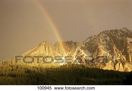 Stock Photography - Rainbow in front of mountain . Fotosearch
