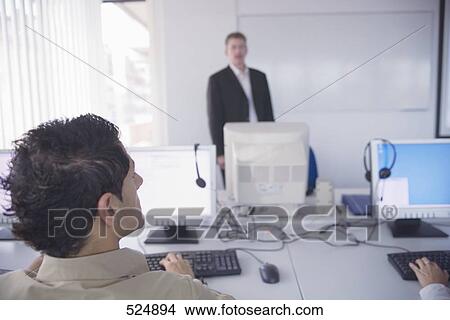 Rear view of businessman working on computer View Large Photo Image Picture - Rear view of businessman working on computer . Fotosearch